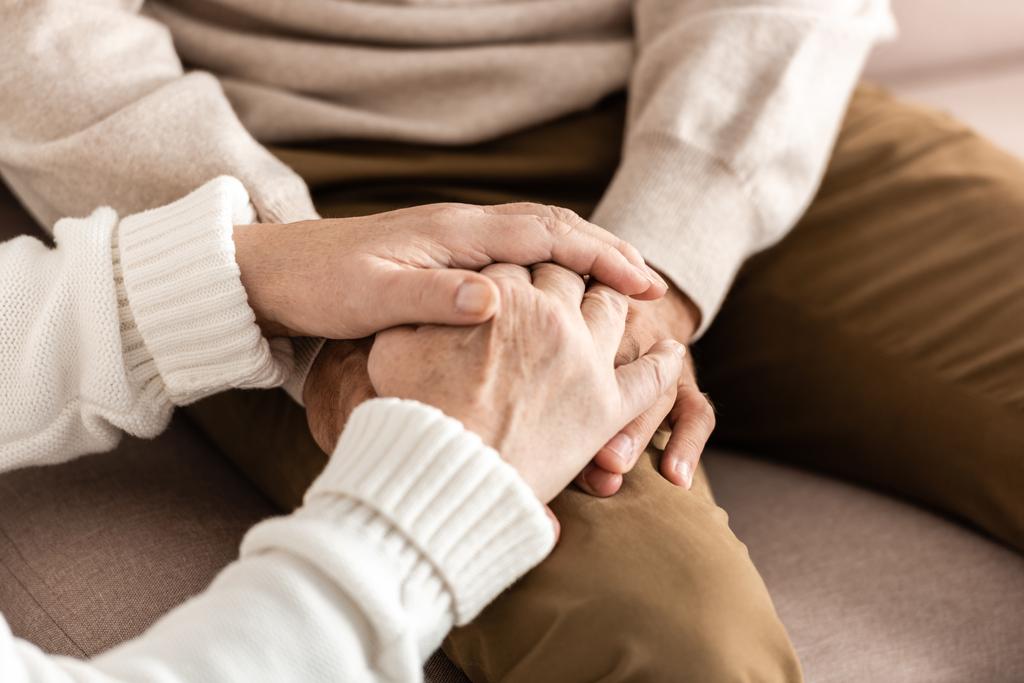 cropped view of senior man and woman holding hands  - Photo, Image