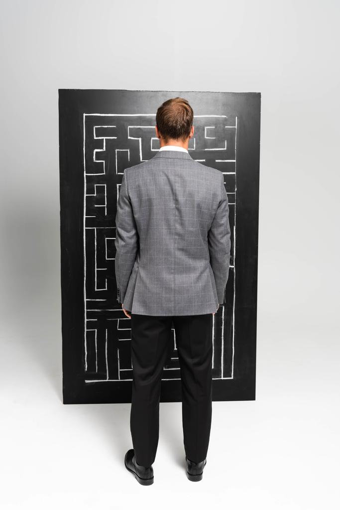 visszapillantás üzletember öltönyben nézi labirintus  - Fotó, kép