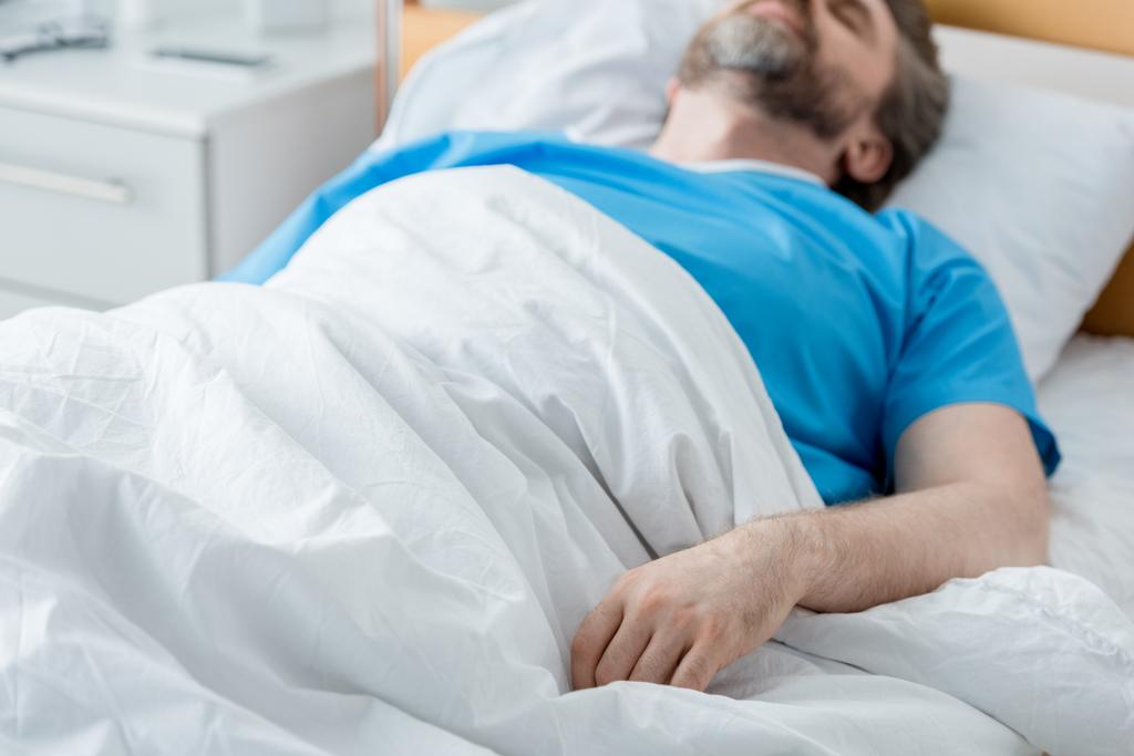 wybiórcze skupienie uwagi pacjenta w sukni medycznej śpiącego w szpitalu  - Zdjęcie, obraz