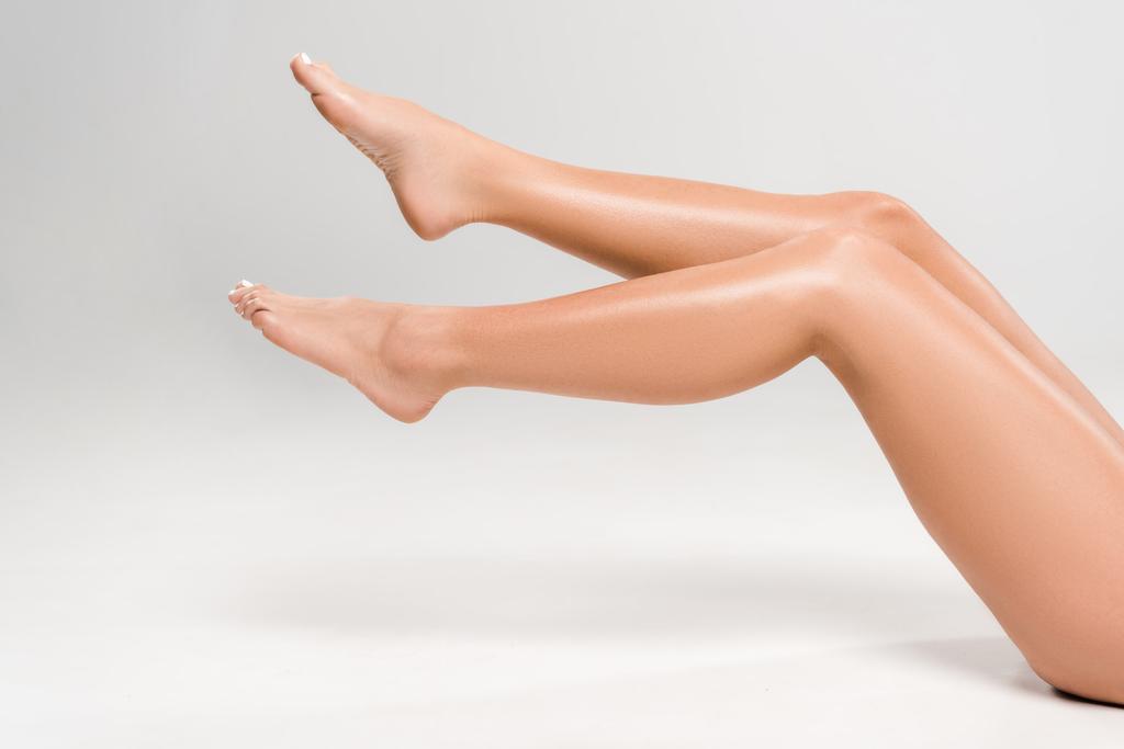 vista cortada de belas pernas femininas no fundo cinza
 - Foto, Imagem