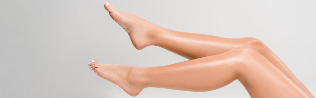 vista recortada de hermosas piernas femeninas sobre fondo gris, plano panorámico
 - Foto, imagen