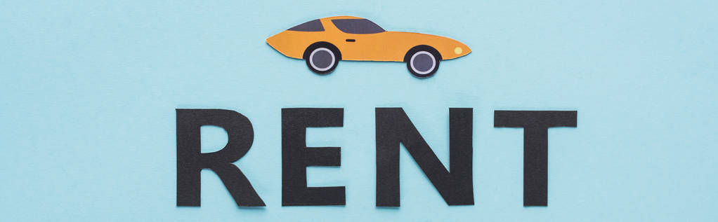 top view of paper cut sports car and black rent lettering on blue background, panoramic shot - Photo, Image