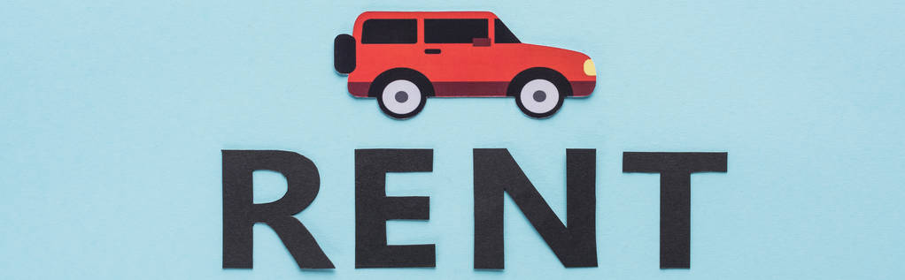 top view of paper cut car and black rent lettering on blue background, panoramic shot - Photo, Image