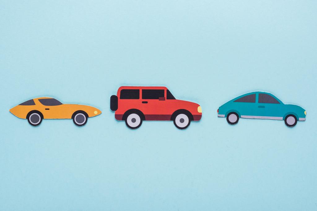 Draufsicht auf Papier schneiden verschiedene Autos auf blauem Hintergrund - Foto, Bild