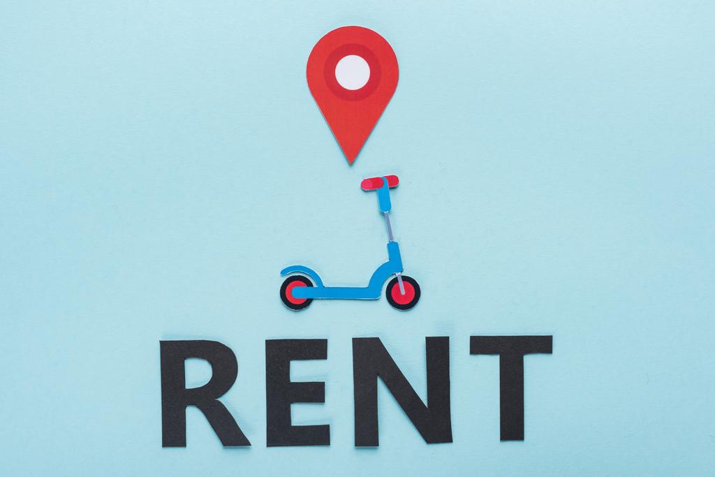 Mavi arkaplanda siyah kira harflerinin yanında konum işaretli kağıt kesim scooter üst görünümü - Fotoğraf, Görsel