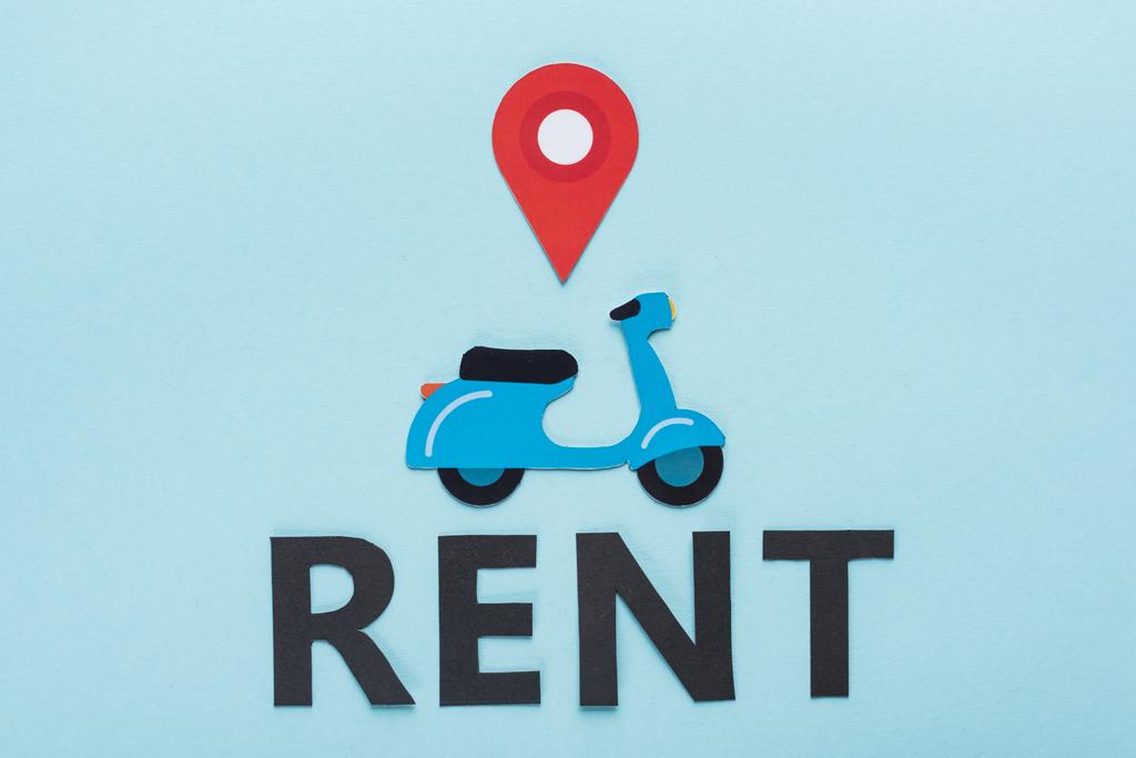 top view of paper cut scooter with location mark near black rent lettering on blue background - Photo, Image