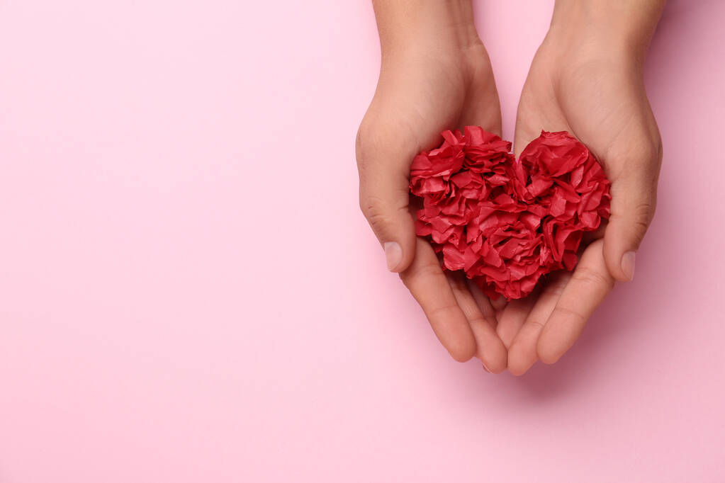 Woman holding red heart on pink background, top view. Space for text - Foto, afbeelding