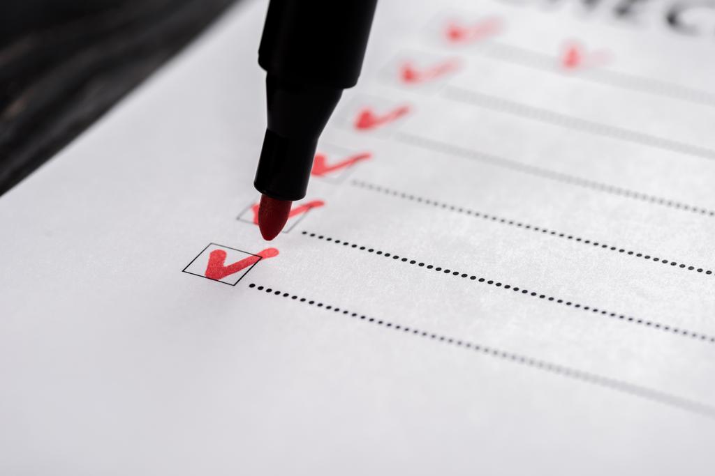 close-up da lista de verificação com carrapatos perto caneta marcador vermelho
  - Foto, Imagem