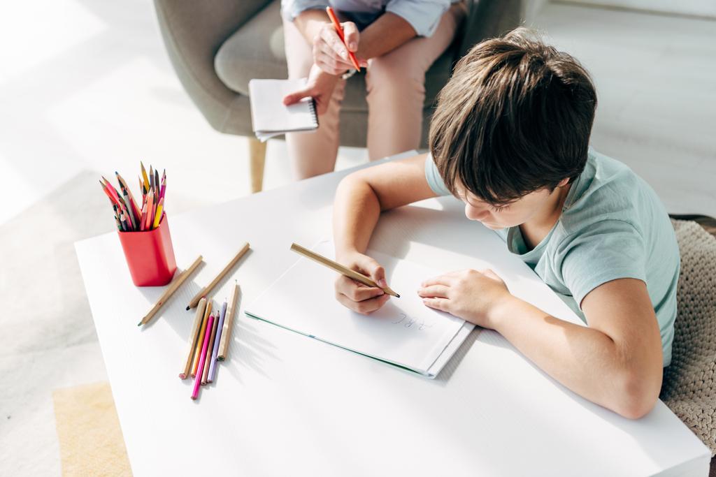 высокий угол обзора ребенка с дислексией рисунок на бумаге с карандашом
  - Фото, изображение