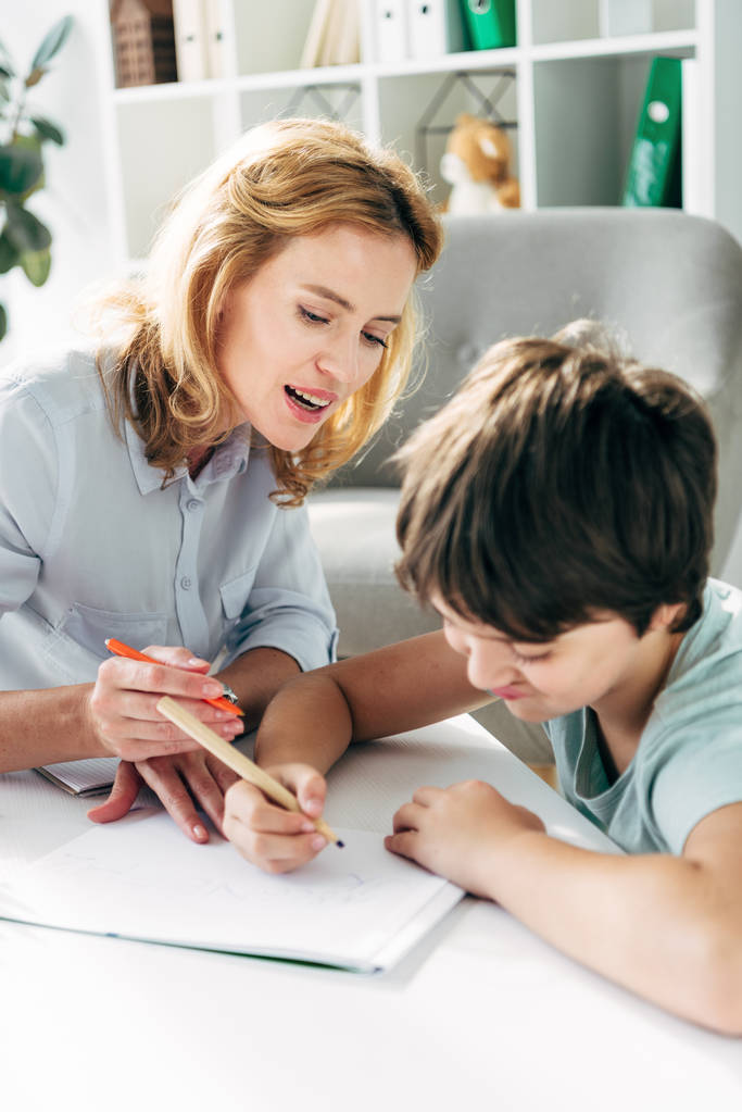 дитина з дислексією і дитячий психолог малюнок з олівцями
  - Фото, зображення