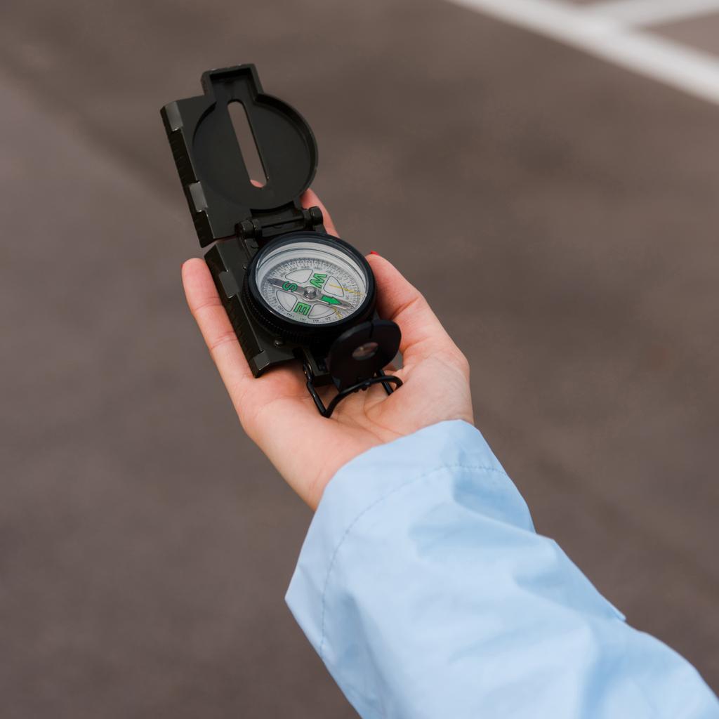 close up of woman holding compass near road  - Photo, Image