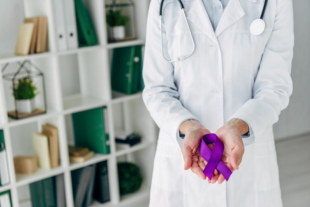 bijgesneden weergave van arts met paars lint in kliniek  - Foto, afbeelding