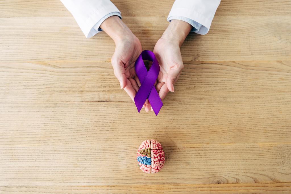 cropped view of doctor holding purple ribbon in clinic  - Photo, Image