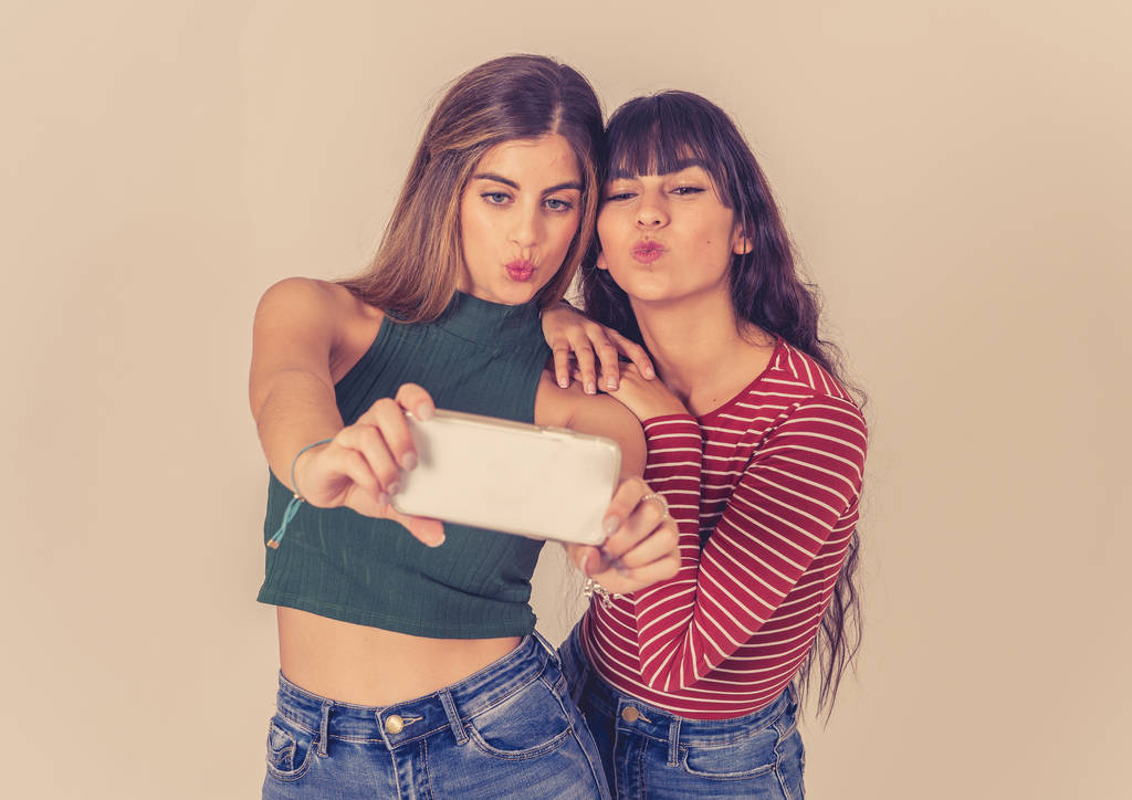 Two beautiful happy girlfriends taking selfies or recording video for blog on social media. Selfie of two beautiful women together having fun. People, technology, friendship and social media concept. - Photo, Image
