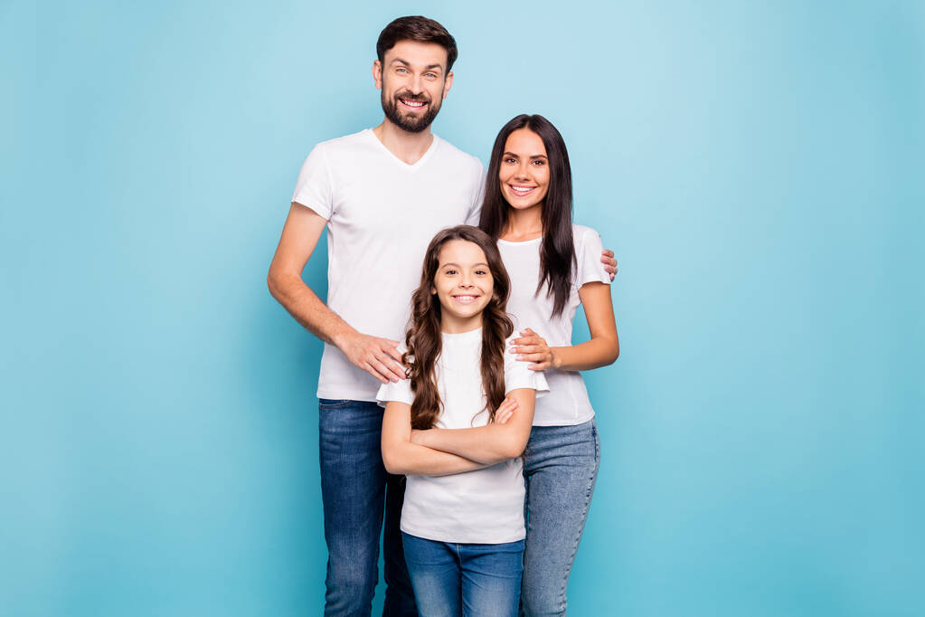 Muotokuva iloinen idyllinen kolme brunette hiukset ihmiset iso perhe luottaa viileä halaus hauskaa pukeutua valkoinen t-paita denim farkut eristetty yli sininen tausta
 - Valokuva, kuva