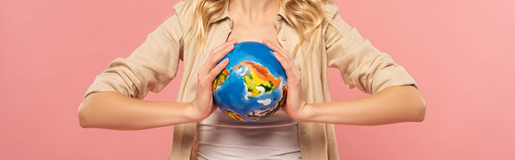 Ausgeschnittene Ansicht einer Frau, die Globus in Händen hält, isoliert auf rosa, panoramische Aufnahme - Foto, Bild