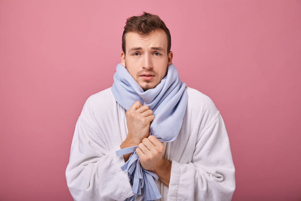sick man in blue scarf and white robe on pink background - Photo, Image