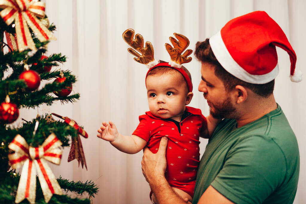 Verspielter Vater zeigt seinem kleinen Sohn den Weihnachtsbaum - Foto, Bild