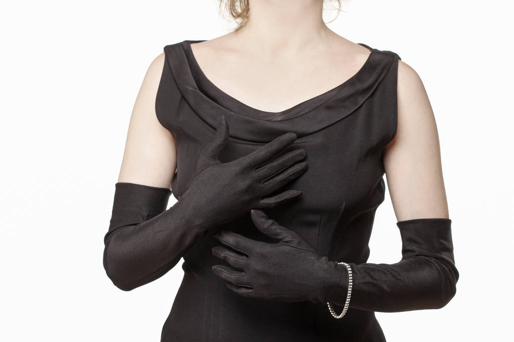 Uma mulher usando um vestido preto luxuoso e luvas longas
. - Foto, Imagem