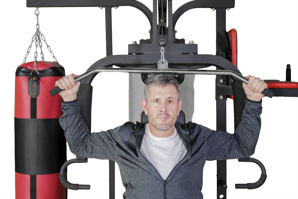 Homem caucasiano com máquina de fitness no estúdio
 - Foto, Imagem