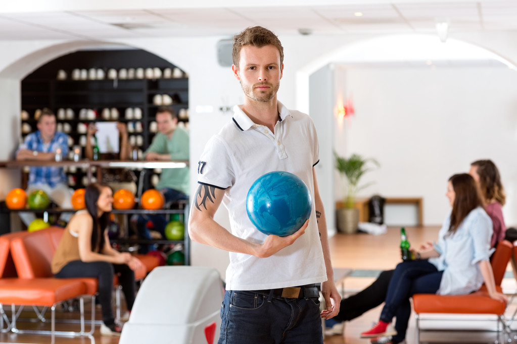 sebevědomý mladý muž s bowlingovou kouli v klubu - Fotografie, Obrázek