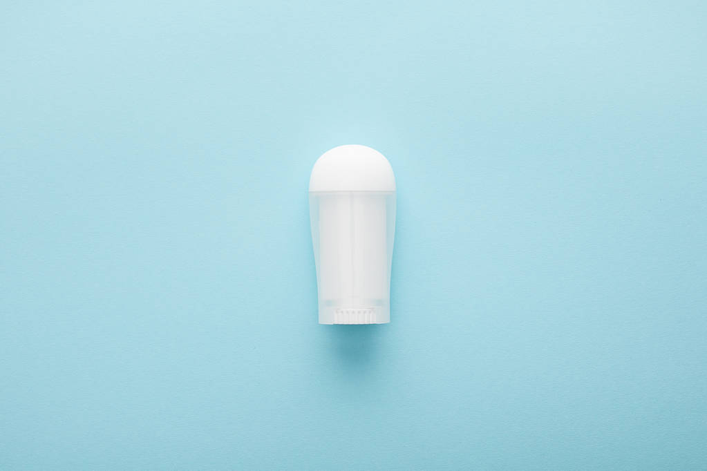 bovenaanzicht van rol op fles deodorant op blauwe achtergrond - Foto, afbeelding