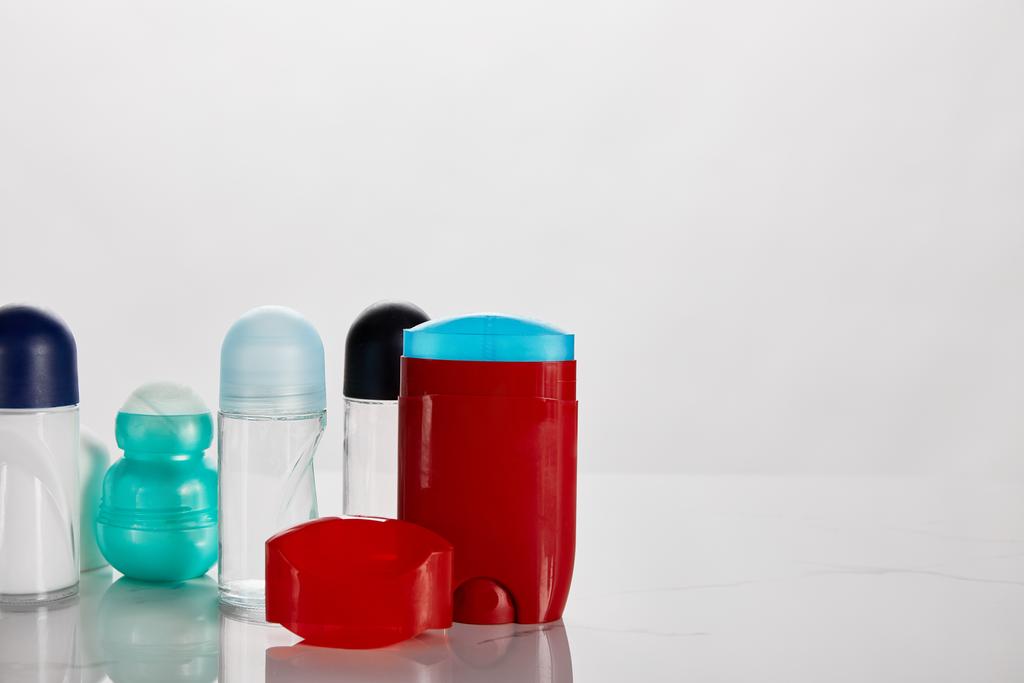 Beyaz üzerine izole edilmiş renkli patenli deodorant şişeleri - Fotoğraf, Görsel