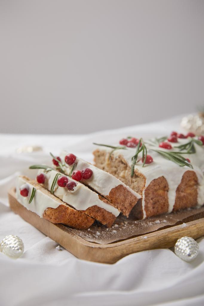 traditional Christmas cake with cranberry on wooden board near silver baubles isolated on grey - Photo, Image