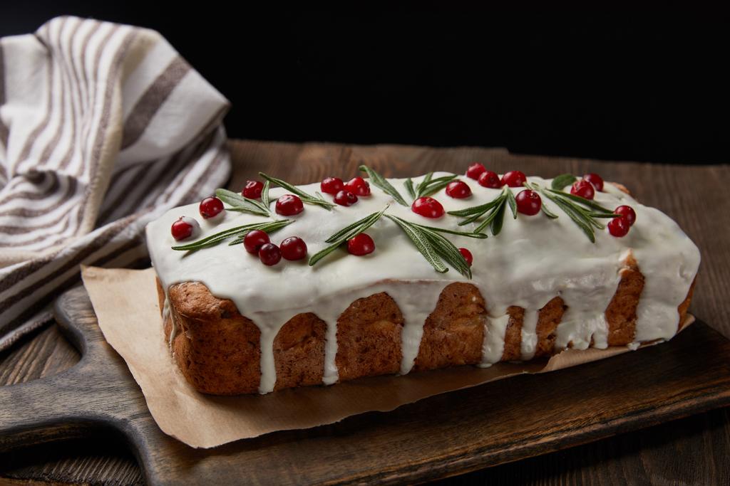 traditional Christmas cake with cranberry and rosemary on wooden table isolated on black - Photo, Image