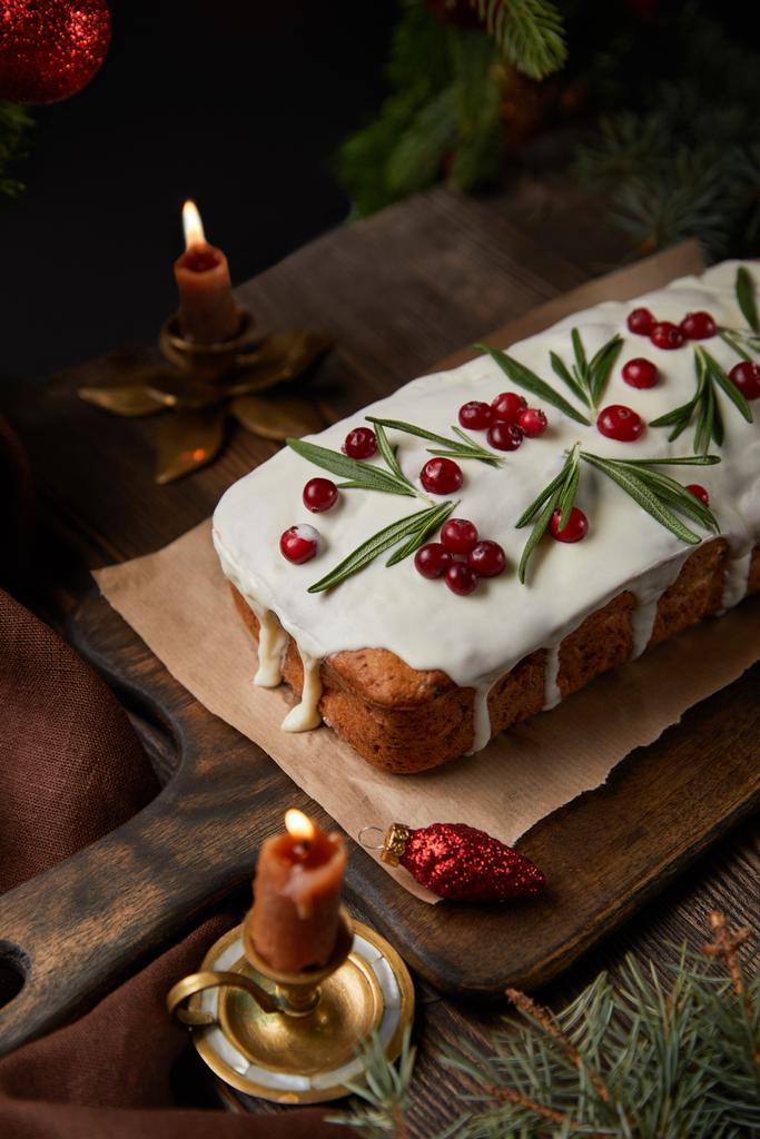 bolo de Natal tradicional com cranberry perto de pinho e velas na mesa de madeira
 - Foto, Imagem