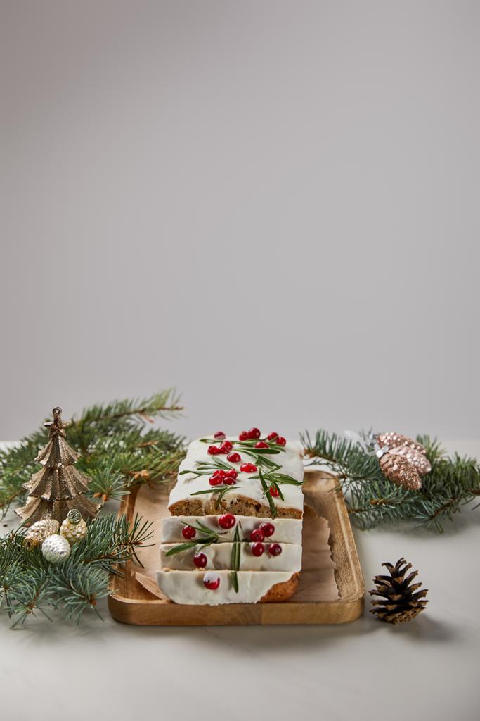 Geleneksel Noel pastası, yaban mersinli. Mücevherlerin yanında ve gri masa üzerinde çam ağacı. - Fotoğraf, Görsel