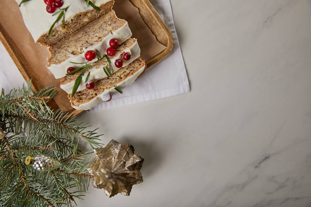 вид зверху традиційний різдвяний торт з журавлиною поблизу дрібниць і сосни на мармуровому столі
 - Фото, зображення
