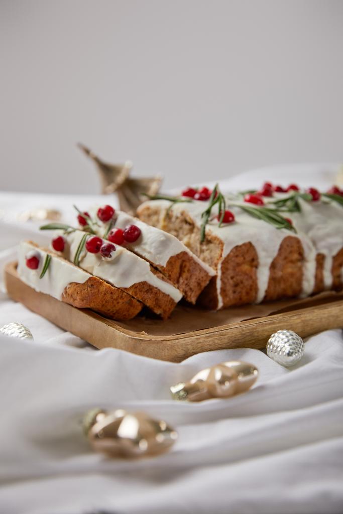 focalizzazione selettiva della tradizionale torta di Natale con mirtillo su tavola di legno vicino alle bagattelle su panno bianco isolato su grigio
 - Foto, immagini