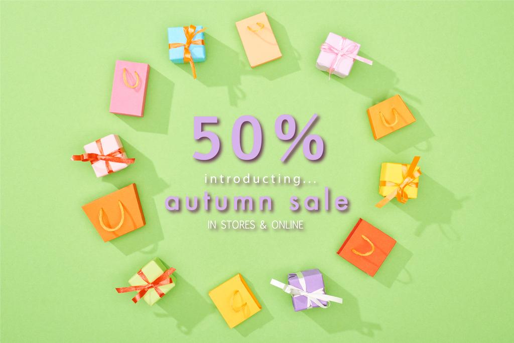 kulatý rám dekorativních dárkových krabic a nákupních tašek na zeleném pozadí s 50% slevou z podzimního prodeje ilustrace  - Fotografie, Obrázek