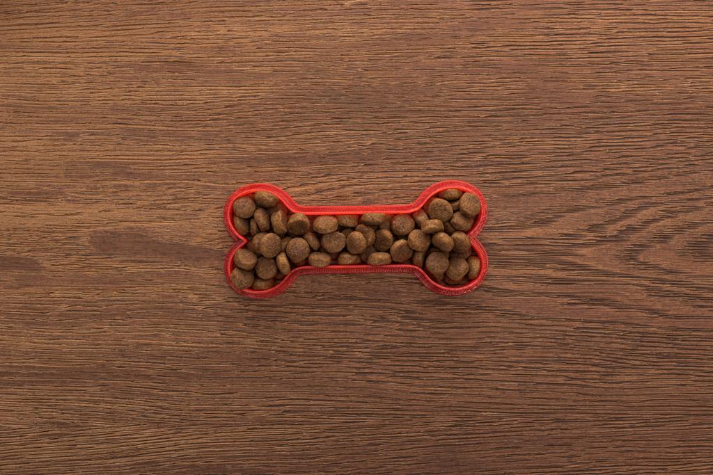 vista superior de comida seca para mascotas en hueso sobre mesa de madera
 - Foto, Imagen