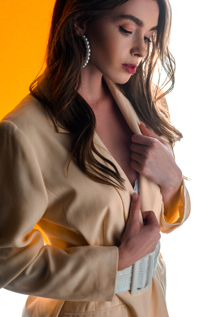 attraente giovane donna toccante blazer su arancione e bianco
  - Foto, immagini