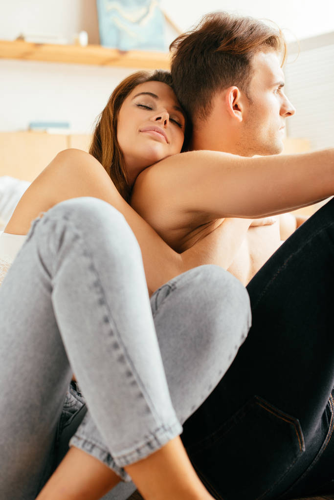 girlfriend with closed eyes hugging handsome boyfriend in apartment  - Photo, Image