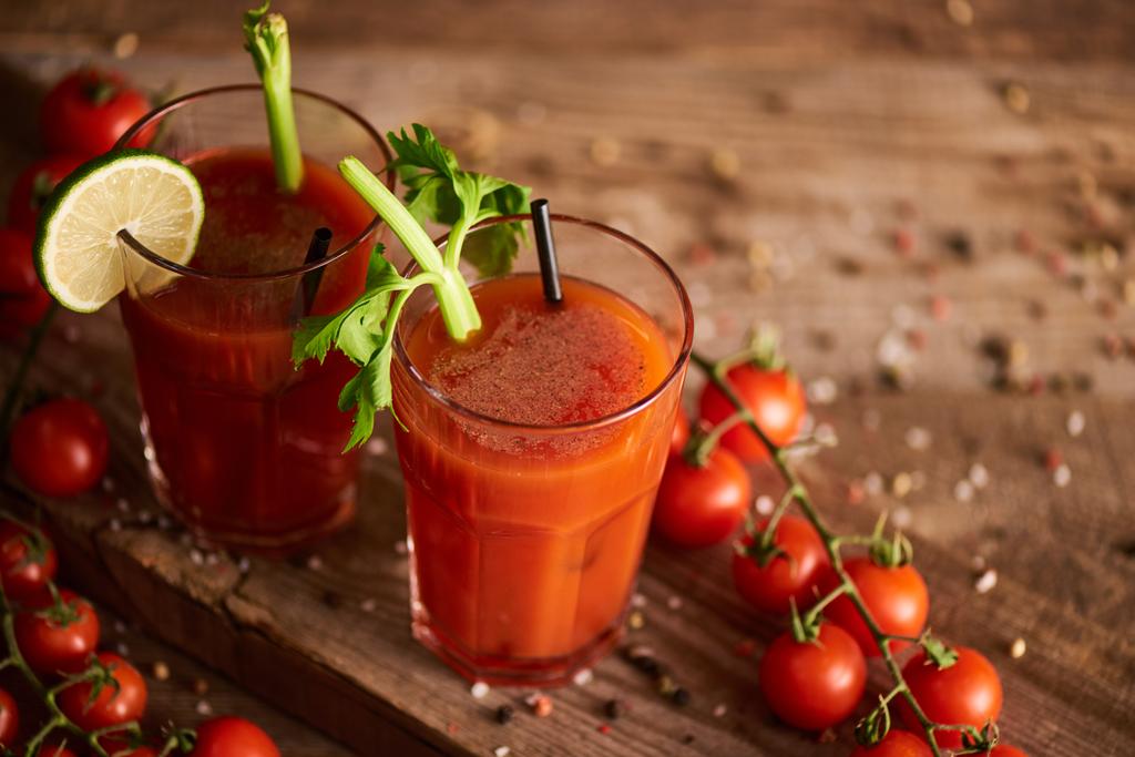 bloody mary cocktail in glasses on wooden background with salt, pepper, tomatoes and celery - Photo, Image