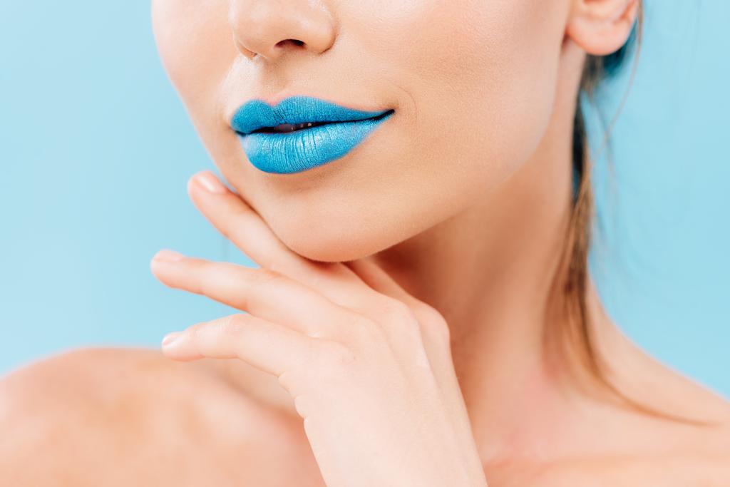 kivágott kilátás meztelen gyönyörű nő kék ajkak pózol kéz közelében arc elszigetelt kék - Fotó, kép