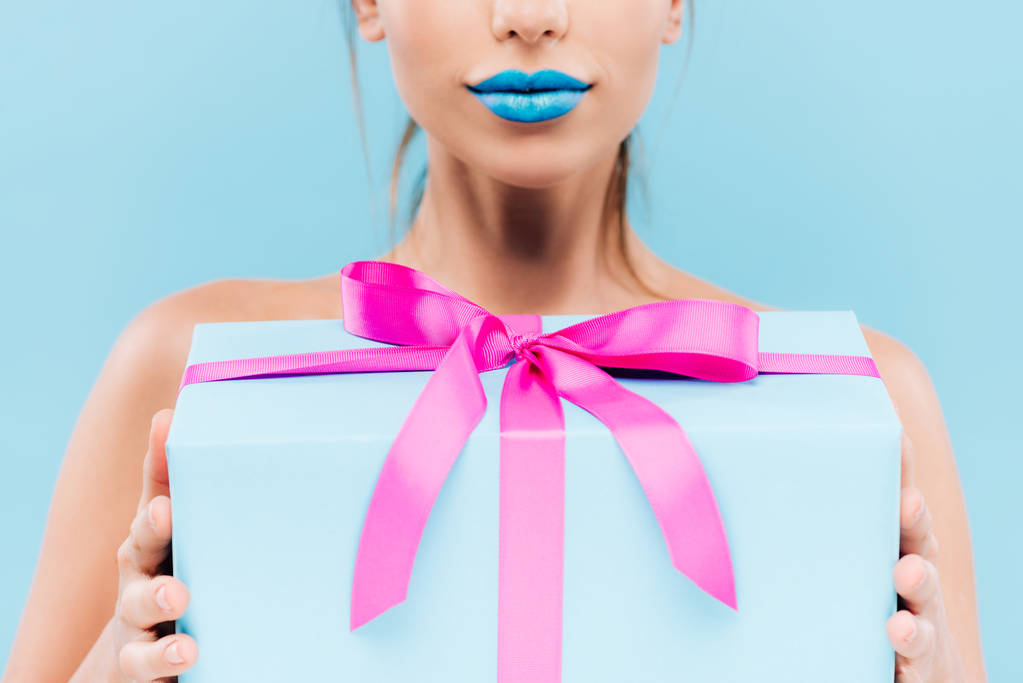 vista ritagliata di bella donna con labbra blu contenente scatola regalo isolato su blu
 - Foto, immagini