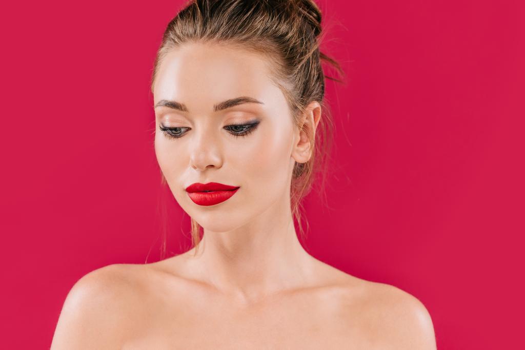 γυμνή όμορφη γυναίκα με κόκκινα χείλη κοιτάζει μακριά απομονωμένη στο κόκκινο - Φωτογραφία, εικόνα