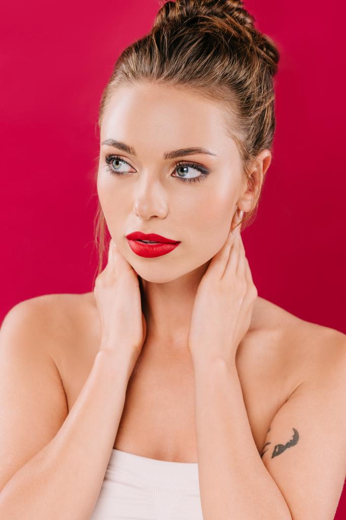 beautiful woman with red lips posing with hands on neck isolated on red - Photo, Image