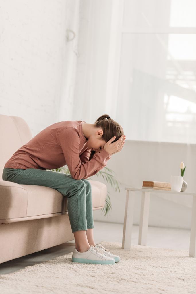 nieszczęśliwa kobieta siedząca na kanapie i cierpiąca na ból głowy - Zdjęcie, obraz