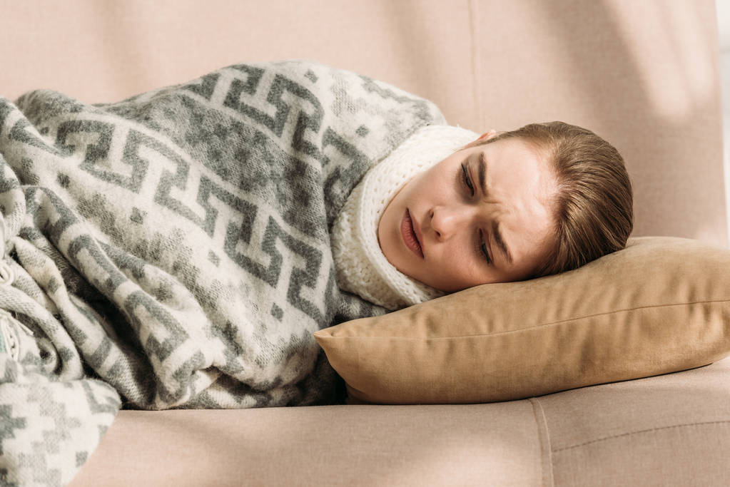 doente, menina chateada deitado no sofá sob cobertor
 - Foto, Imagem