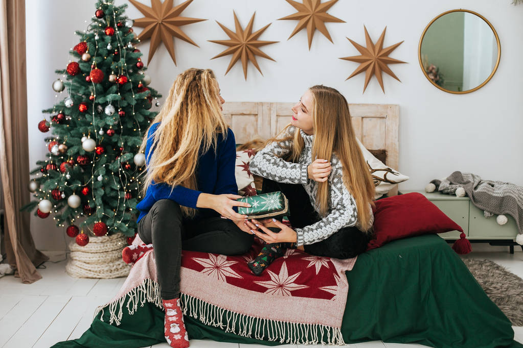 Duas mulheres loiras bonitas jovens comemorando o Natal
 - Foto, Imagem