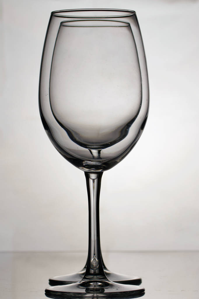 Copos de vidro de vinho em uma perna longa. Dois copos para a luz, um por um
. - Foto, Imagem