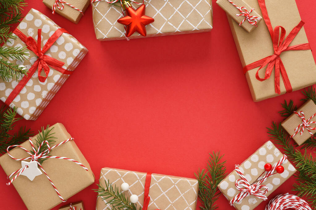 Weihnachtsrahmen mit Geschenkschachteln und Dekoration auf rotem Hintergrund - Foto, Bild