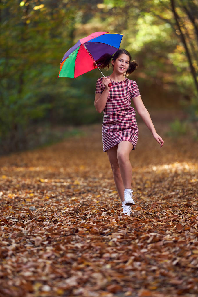 Portrait d'une jolie écolière marchant dans la forêt à l'automne
 - Photo, image