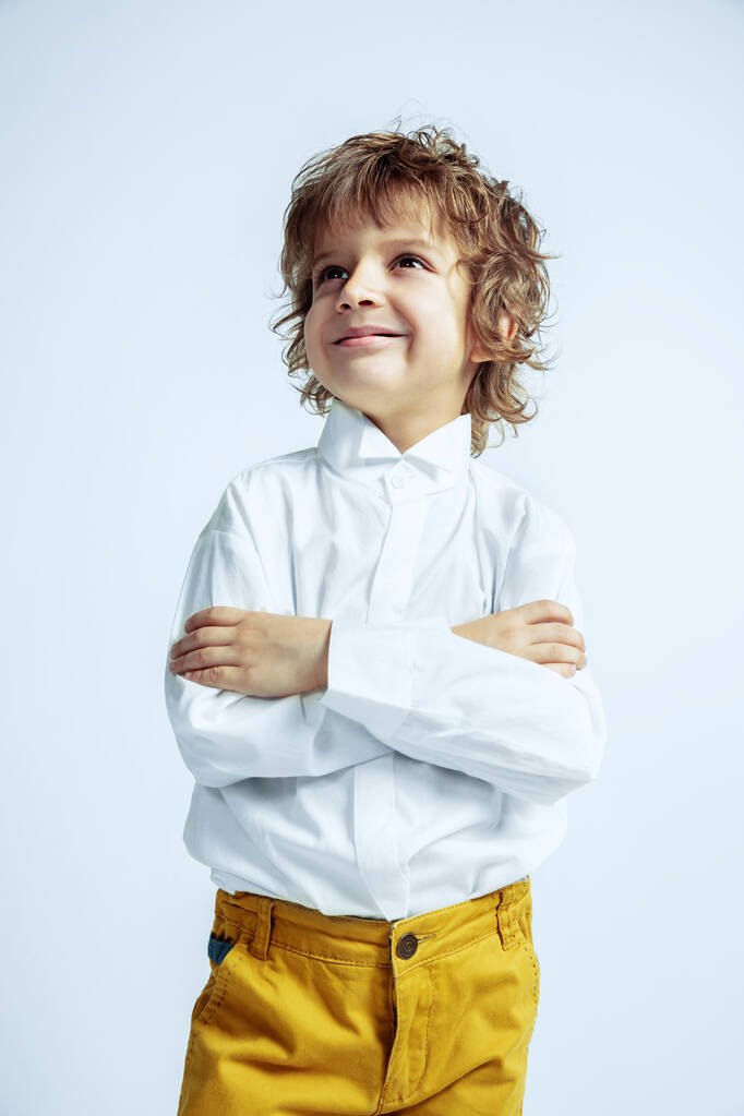 Όμορφο νεαρό αγόρι με casual ρούχα σε λευκό φόντο στούντιο - Φωτογραφία, εικόνα