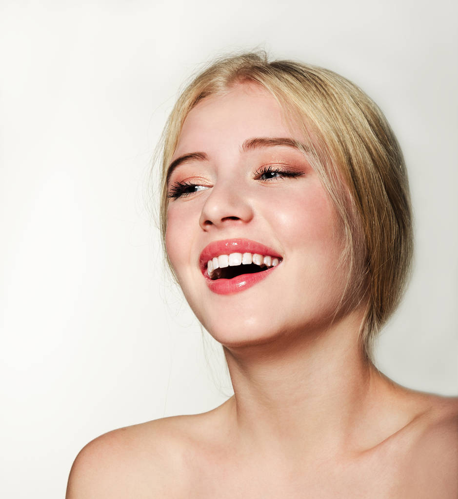 Πορτρέτο του γέλιου όμορφη ξανθιά νεαρή γυναίκα πρόσωπο. Spa μοντέλο κορίτσι με φρέσκο καθαρό δέρμα απομονώνονται σε λευκό φόντο. Έννοια οδοντιατρικής περίθαλψης - Φωτογραφία, εικόνα